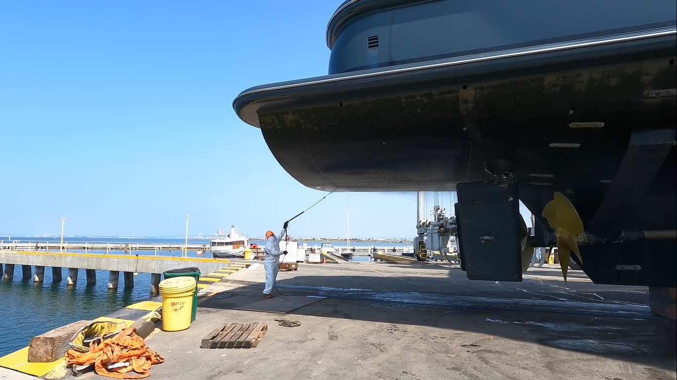 MGBW employee power washing Revelry hull.